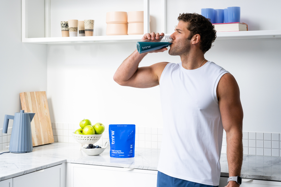 Man drinking Tmrw in a bright kitchen.