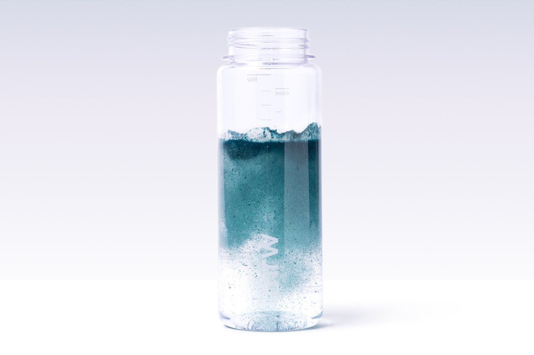 Blue Tmrw powder dissolving in water bottle.